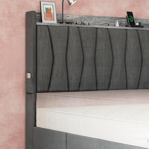 Full size dark grey upholstered platform bed with padded linen headboard, built-in storage shelf and charging station, and three underbed rolling drawers for extra storage.