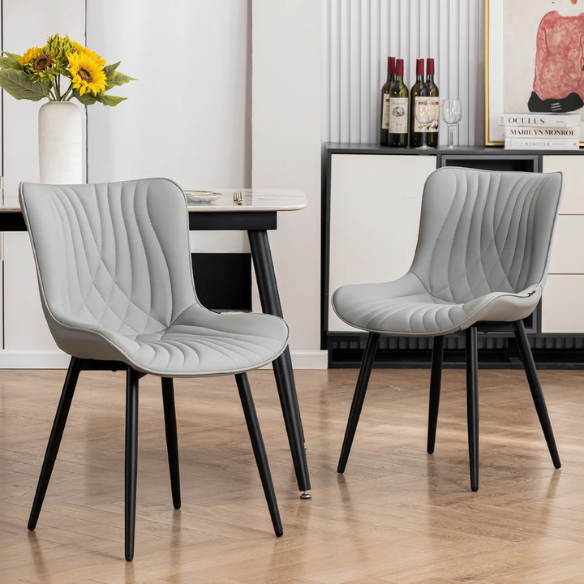 Set of 2 grey faux leather dining chairs with fishtail tufted backs and black metal legs, ideal for modern and minimalist dining room interiors.