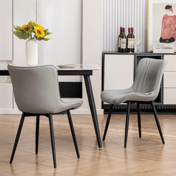 Set of 2 grey faux leather dining chairs with fishtail tufted backs and black metal legs, ideal for modern and minimalist dining room interiors.