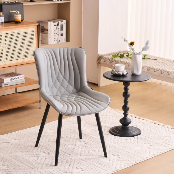 Set of 2 grey faux leather dining chairs with fishtail tufted backs and black metal legs, ideal for modern and minimalist dining room interiors.