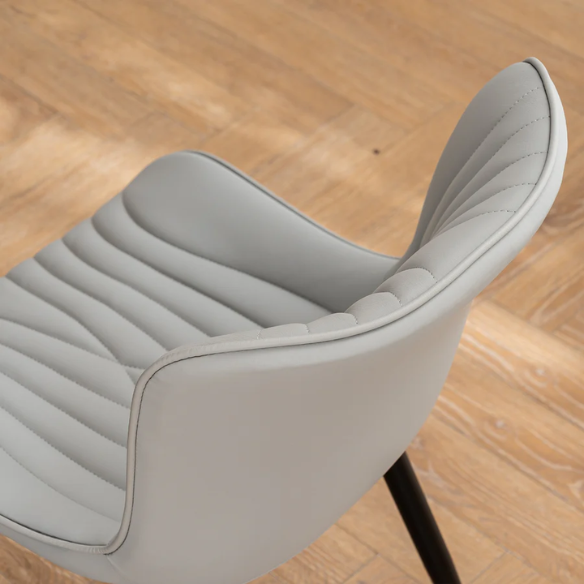 Set of 2 grey faux leather dining chairs with fishtail tufted backs and black metal legs, ideal for modern and minimalist dining room interiors.