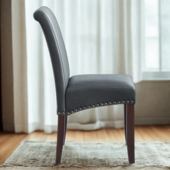 Grey leather Parsons chair with high back, scrolled shoulders, antique bronze nailhead trim, and solid wood legs