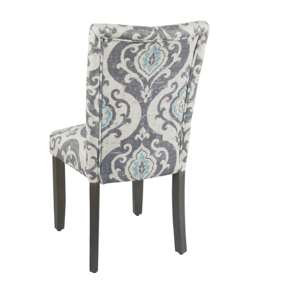 Set of two Parsons dining chairs with grey, white, and light blue floral upholstery, high back design, scalloped seat front, and wood legs