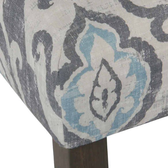 Set of two Parsons dining chairs with grey, white, and light blue floral upholstery, high back design, scalloped seat front, and wood legs