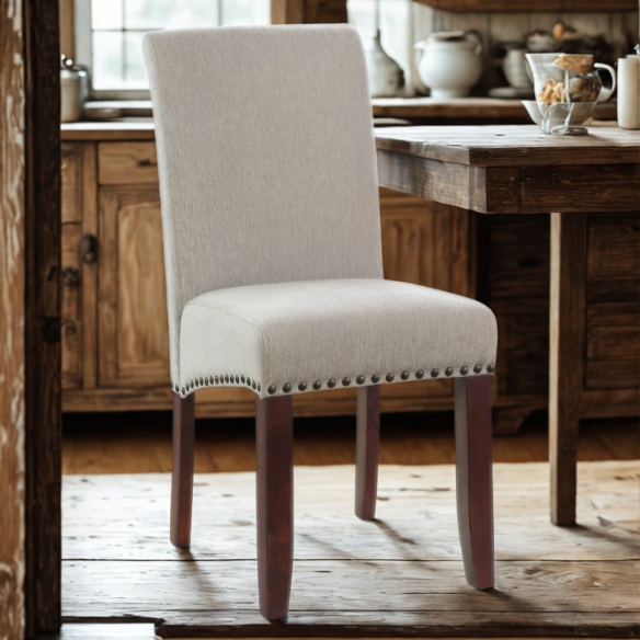 Light grey upholstered Parsons chair with scrolled high back, antique bronze nailhead trim, and solid wood legs