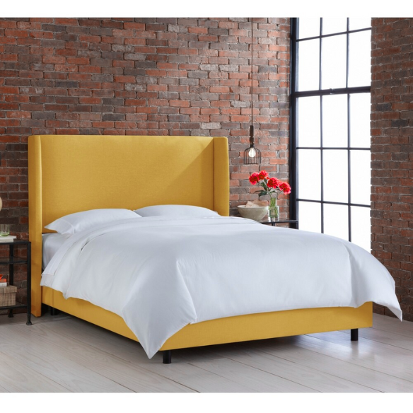 Mustard yellow king-size upholstered bed in linen fabric with wingback headboard and low-profile black metal legs.