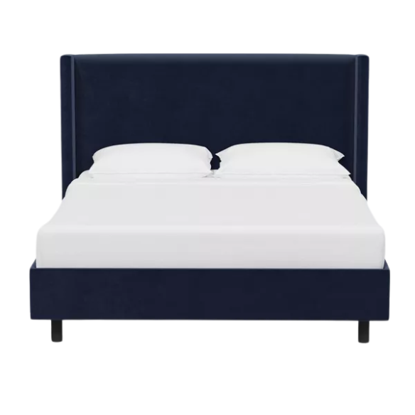 Navy blue king-size upholstered bed in velvet fabric with wingback headboard and low-profile black metal legs.