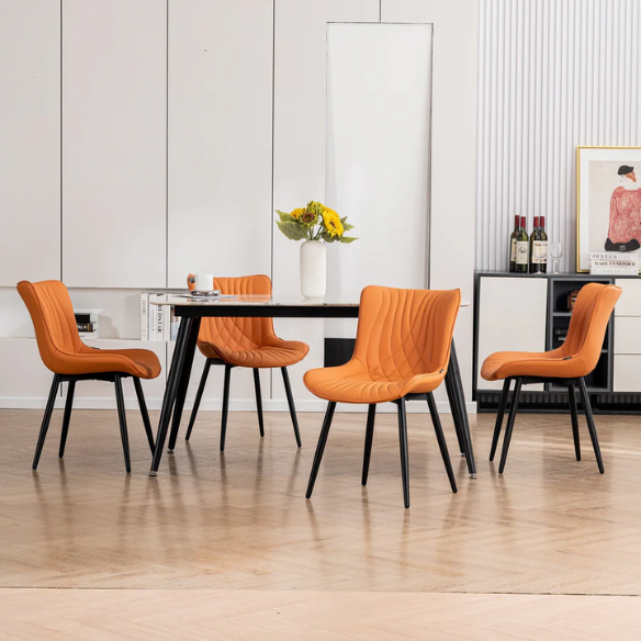Set of 2 orange faux leather dining chairs with fishtail tufted backs and black metal legs, perfect for modern and colorful dining room settings.