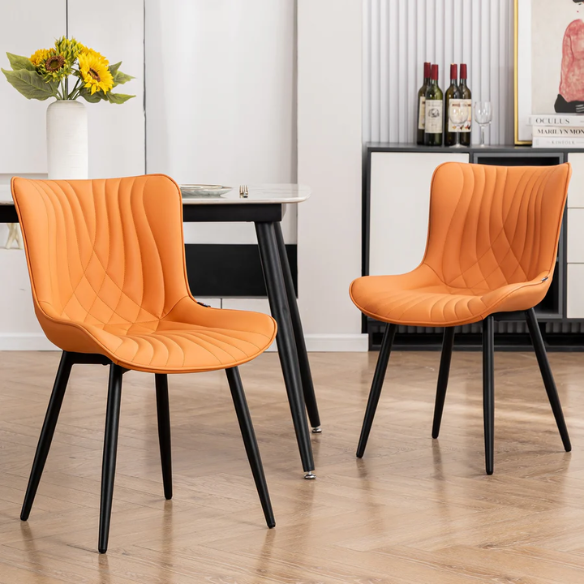 Set of 2 orange faux leather dining chairs with fishtail tufted backs and black metal legs, perfect for modern and colorful dining room settings.