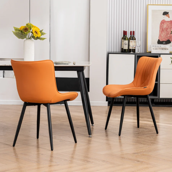Set of 2 orange faux leather dining chairs with fishtail tufted backs and black metal legs, perfect for modern and colorful dining room settings.