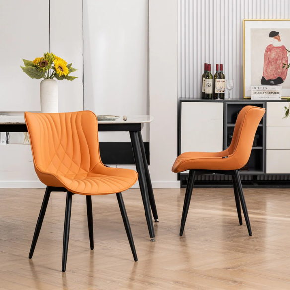 Set of 2 orange faux leather dining chairs with fishtail tufted backs and black metal legs, perfect for modern and colorful dining room settings.