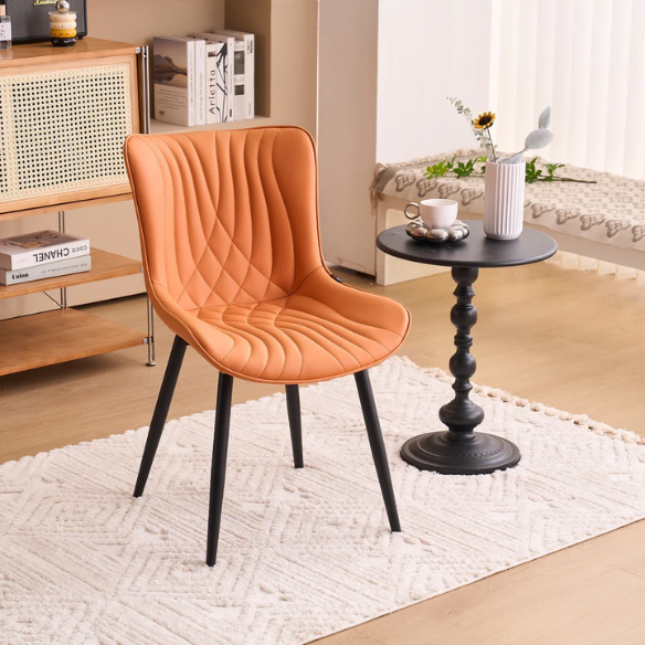 Set of 2 orange faux leather dining chairs with fishtail tufted backs and black metal legs, perfect for modern and colorful dining room settings.