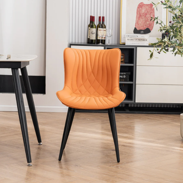 Set of 2 orange faux leather dining chairs with fishtail tufted backs and black metal legs, perfect for modern and colorful dining room settings.