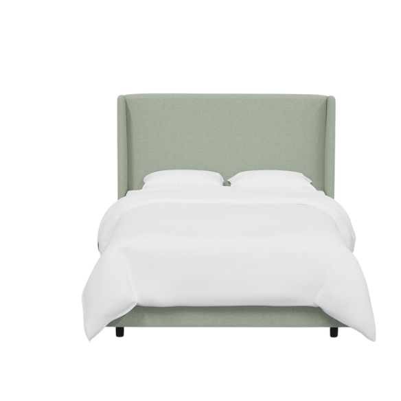 Sage green king-size upholstered bed in linen fabric with wingback headboard and low-profile black metal legs.
