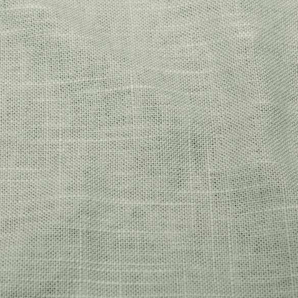 Sage green king-size upholstered bed in linen fabric with wingback headboard and low-profile black metal legs.