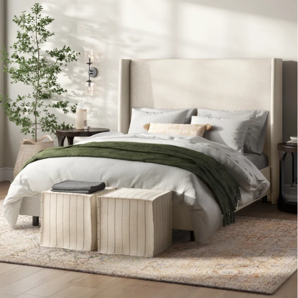 Talc king-size upholstered bed in linen fabric with wingback headboard and low-profile black metal legs.