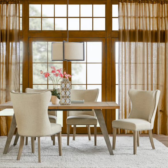 Set of two cream upholstered dining chairs with curved wingback design, dark pewter nailhead trim, and latte wood legs in a traditional style