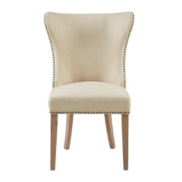 Set of two cream upholstered dining chairs with curved wingback design, dark pewter nailhead trim, and latte wood legs in a traditional style