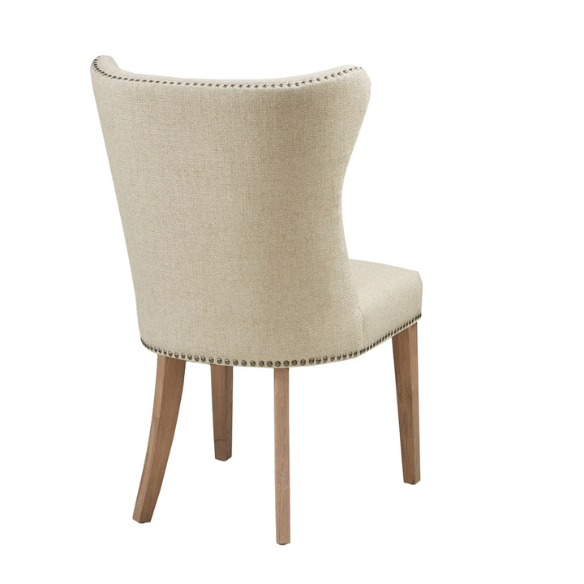 Set of two cream upholstered dining chairs with curved wingback design, dark pewter nailhead trim, and latte wood legs in a traditional style