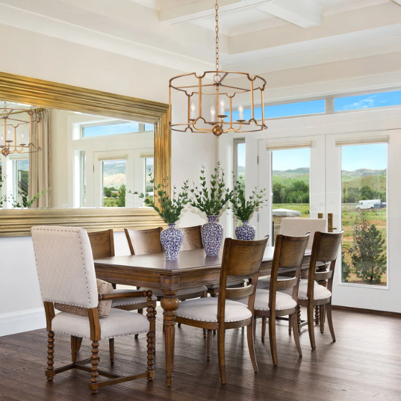 Mid-century modern brass drum chandelier with four candelabra lights in an open lantern frame, ideal for farmhouse and transitional interiors.