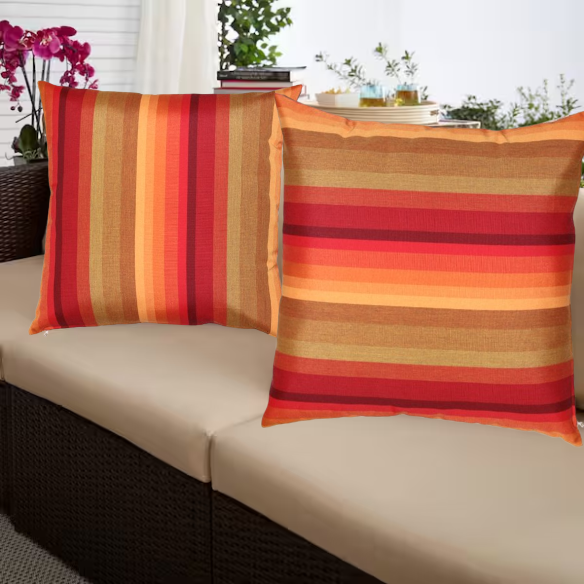 Striped accent pillow in red, orange, and brown – reversible, weather-resistant, and overstuffed for cozy indoor or outdoor décor.