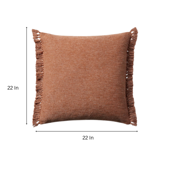 Rust cotton blend throw pillow with fringe, 22x22 square decorative cushion styled on a neutral-toned sofa for cozy, modern home décor.