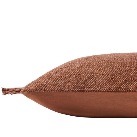 Rust cotton blend throw pillow with fringe, 22x22 square decorative cushion styled on a neutral-toned sofa for cozy, modern home décor.