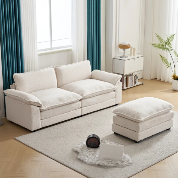 Soft warm cream modular cloud sofa with deep foam cushions, pillow top arms, and a matching free-standing ottoman