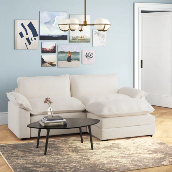 Soft warm cream modular cloud sofa with deep foam cushions, pillow top arms, and a matching free-standing ottoman