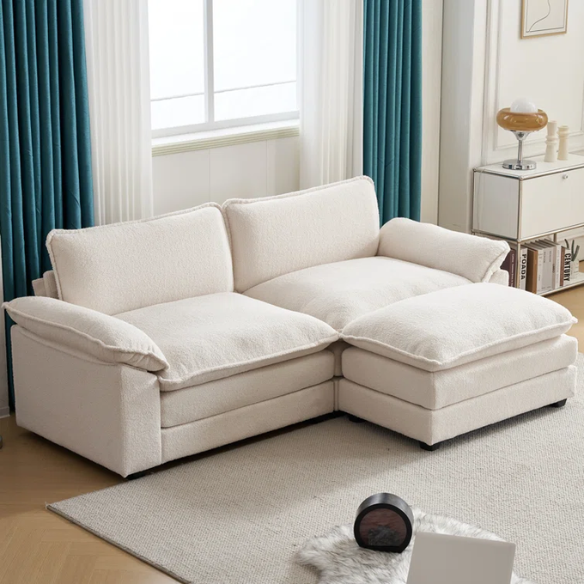 Soft warm cream modular cloud sofa with deep foam cushions, pillow top arms, and a matching free-standing ottoman