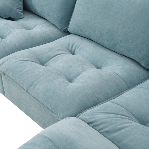Tranquil sea blue suede L-shaped sectional sofa with tufted seat cushions, reversible chaise, removable ottoman, and two matching throw pillows