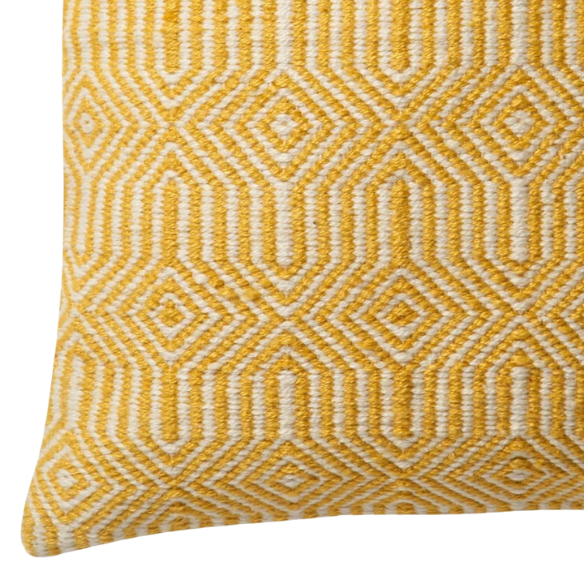 Yellow and cream geometric throw pillow on a bright outdoor chair with summer decor