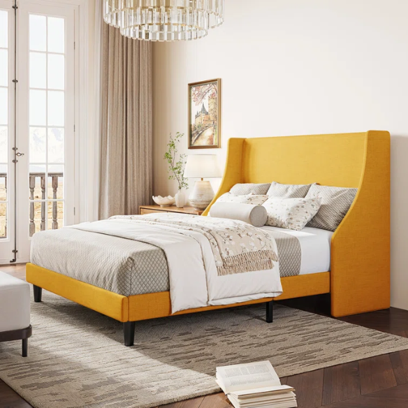 Yellow linen upholstered queen platform bed with wingback headboard, slatted base, and black tapered legs – no box spring required