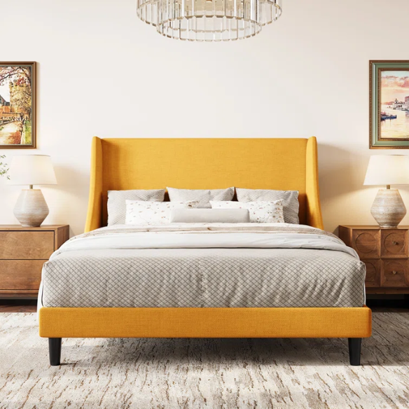 Yellow linen upholstered queen platform bed with wingback headboard, slatted base, and black tapered legs – no box spring required