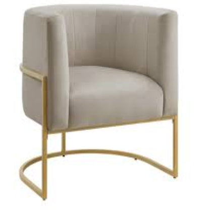 Taupe velvet barrel accent chair with gold accents and a hidden, storable ottoman. Features flared arms, foam-filled seat and back for comfort, a solid wood frame with a sled base for stability, and includes toss pillows for added comfort. The ottoman conveniently tucks under the chair to save space, creating a stylish, space-saving solution for any room.