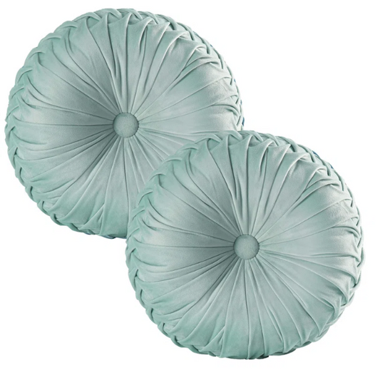 Aqua velvet round throw pillows with hand-sewn pleats and central button, set of two 14.5-inch decorative cushions styled on a modern sofa.

