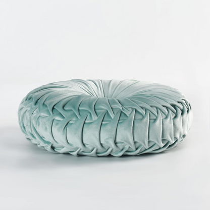 Aqua velvet round throw pillows with hand-sewn pleats and central button, set of two 14.5-inch decorative cushions styled on a modern sofa.

