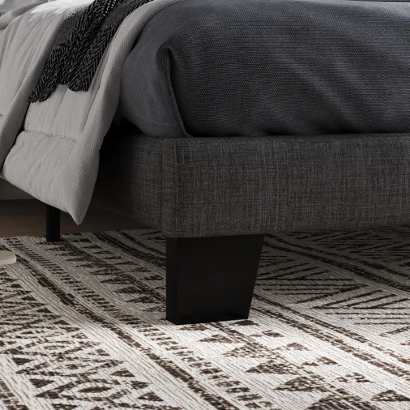 Dark grey upholstered queen platform bed with tufted headboard and wood slat support system