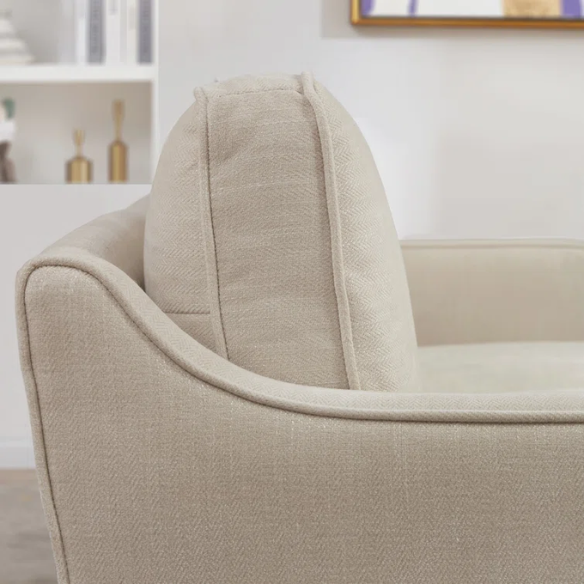 Beige chenille upholstered sofa with curved track arms, loose back cushions, and brown tapered wood legs, in a mid-century modern design.