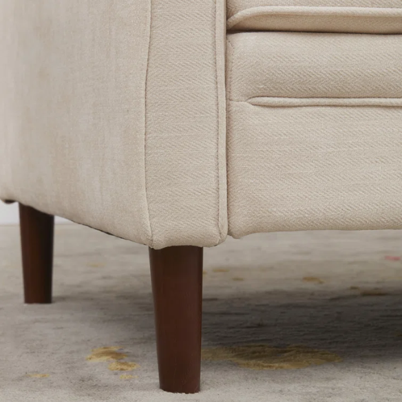 Beige chenille upholstered sofa with curved track arms, loose back cushions, and brown tapered wood legs, in a mid-century modern design.