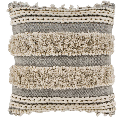 Beige and cream boho accent pillow with tassels and striped texture on a cozy neutral-toned sofa


