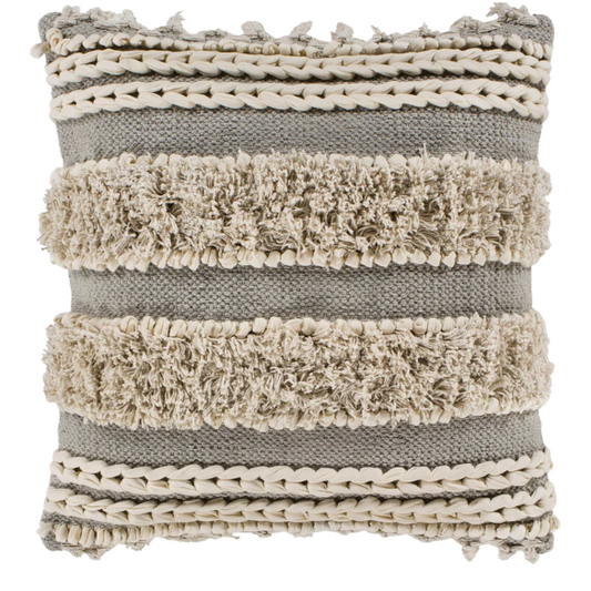 Beige and cream boho accent pillow with tassels and striped texture on a cozy neutral-toned sofa

