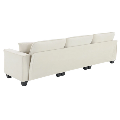 Beige suede L-shaped sectional sofa with removable ottoman, tufted seat cushions, and two matching accent pillows