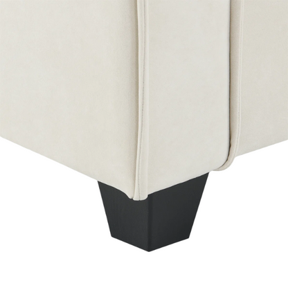 Beige suede L-shaped sectional sofa with removable ottoman, tufted seat cushions, and two matching accent pillows