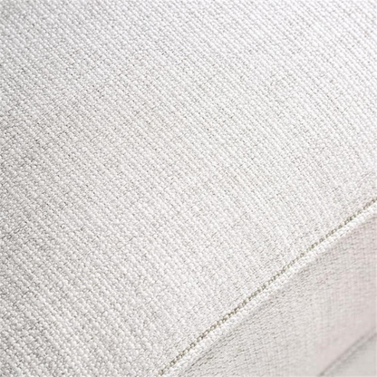 Beige tufted linen sofa with rolled arms, nailhead trim, tapered wooden legs, and accent pillows in transitional style.

