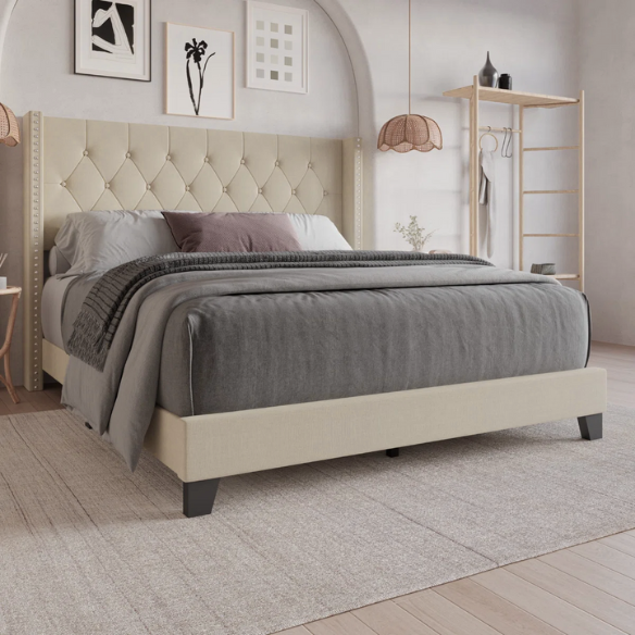 Beige full-size upholstered bed with wingback tufted headboard and nailhead trim