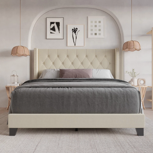 Beige full-size upholstered bed with wingback tufted headboard and nailhead trim