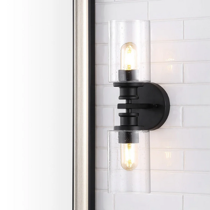 Art Deco-style black wall sconce with dual clear seeded glass cylinder shades and Edison-style LED bulbs, suitable for bathroom or hallway lighting

