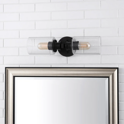 Art Deco-style black wall sconce with dual clear seeded glass cylinder shades and Edison-style LED bulbs, suitable for bathroom or hallway lighting

