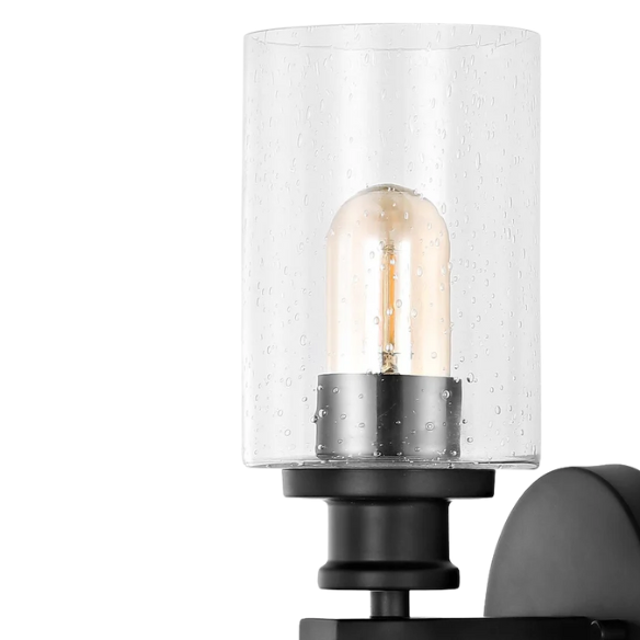 Art Deco-style black wall sconce with dual clear seeded glass cylinder shades and Edison-style LED bulbs, suitable for bathroom or hallway lighting

